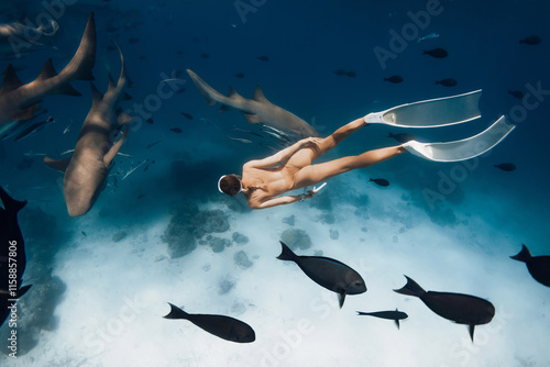 Valokuva Beauty slim freediver woman swimming with nurse sharks in ocean