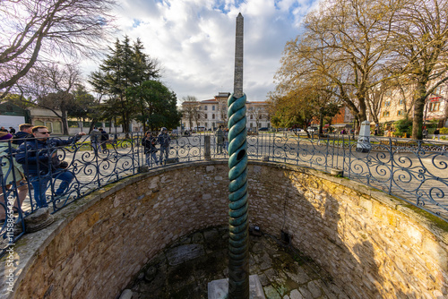 Serpentine Column (Turkish: Yilanlı Sutun) behind Ibrahim Pasha Palace at Sultanahmet Hippodrome Square on in Istanbul, Turkey. photo