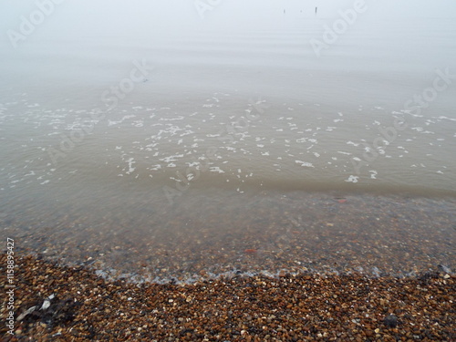 The sea and a shingle beach with the tide coming in waves photo