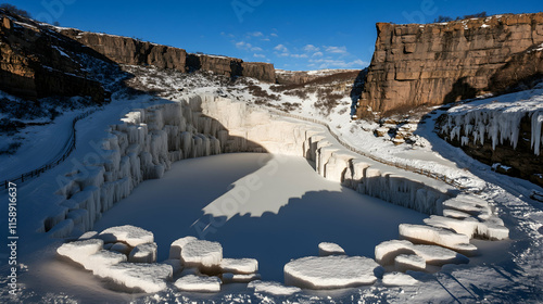 Frozen waterfall in winter landscape, icicles, snow, rocks, canyon.