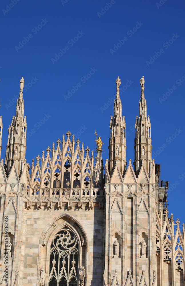 facade of the Duomo with the golden statue of the Madonna and the tall spires in Milan in Italy facade of the Duomo with the golden statue of the Madonna and the tall spires in Milan in Italy
