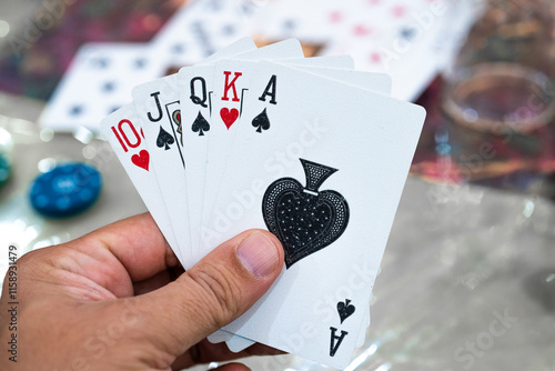 Man holding cards with royal flush but different suites showing a lucky hand in poker, rummy, teen patti and other card games