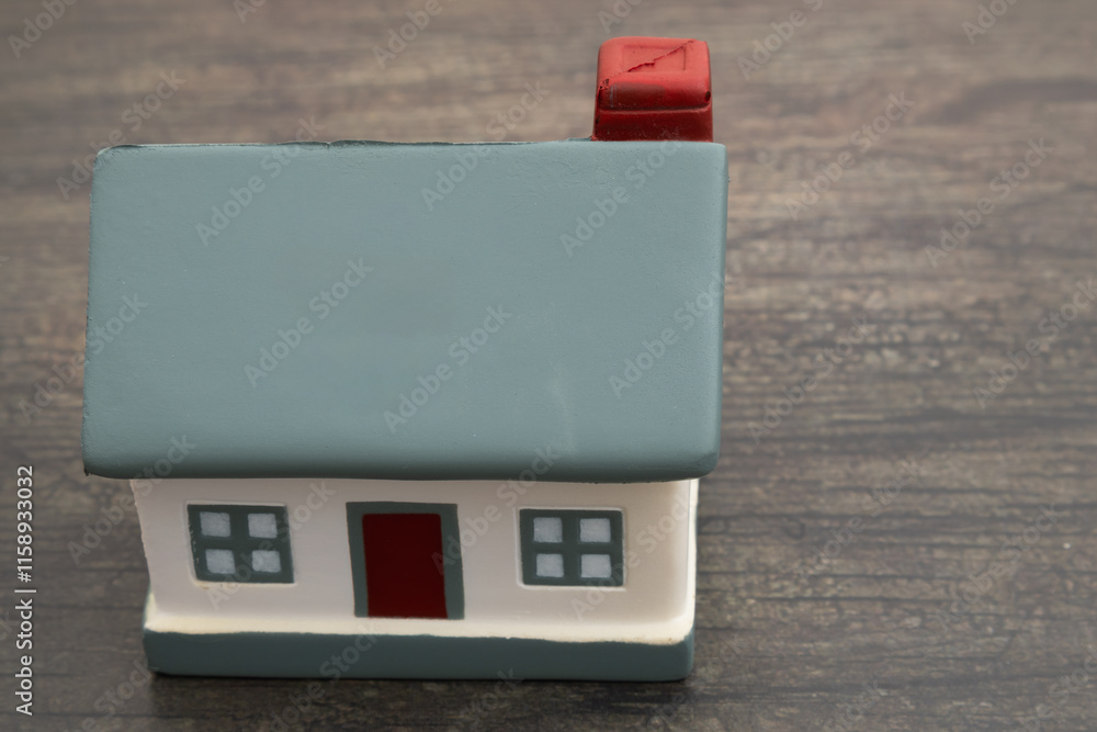 Obraz premium Troubled housing market with a house on weathered wood desk