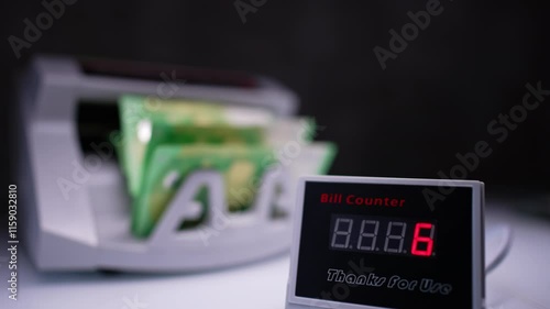 Wallpaper Mural Bill counter interface displays numbers increasing quickly. Close up. Green banknotes are counted fast in cash counting machine at backdrop in blur. Torontodigital.ca