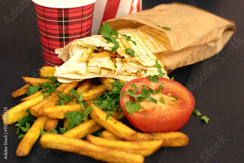 French fries, shawarma, slice of a tomato and paper coffee cup	