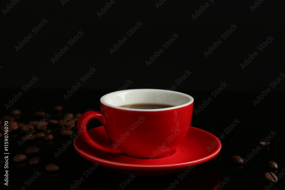 Red cup with coffee and roasted beans on black background Red cup with coffee and roasted beans on black background