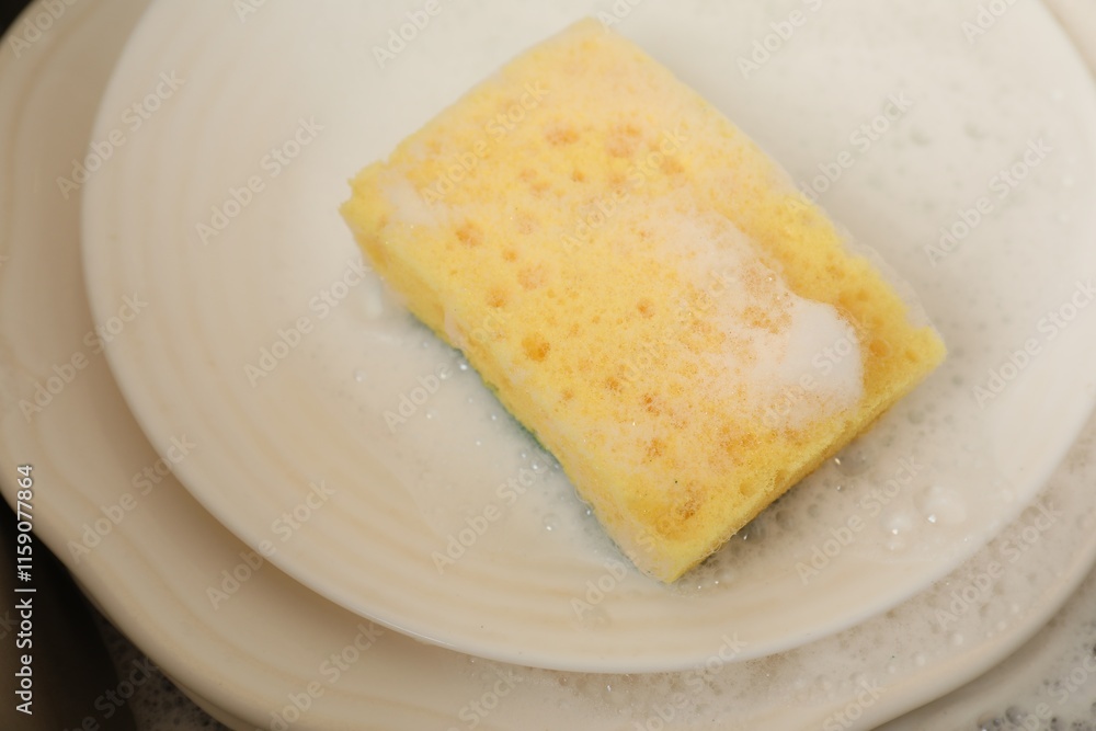 Yellow sponge, dishes and foam in sink, closeup Yellow sponge, dishes and foam in sink, closeup