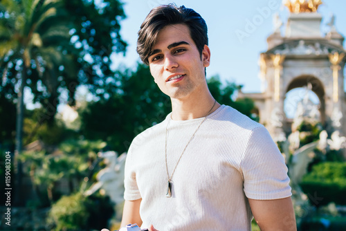 Portrait of handsome positive caucasian male looking at camera standing on urban setting historical center on summer sunny day, amaterur photographer enjoying exploring destination on weekends #1159083204