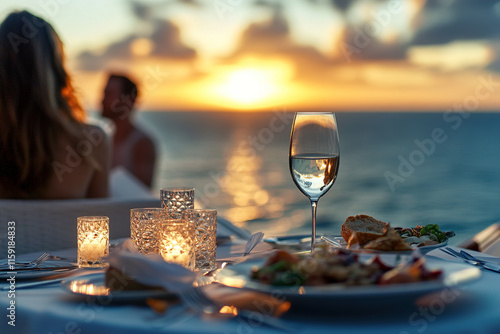 Fototapeta Naklejka Na Ścianę i Meble -  Romantic seaside dinner at sunset with elegant dining setup and delicious food