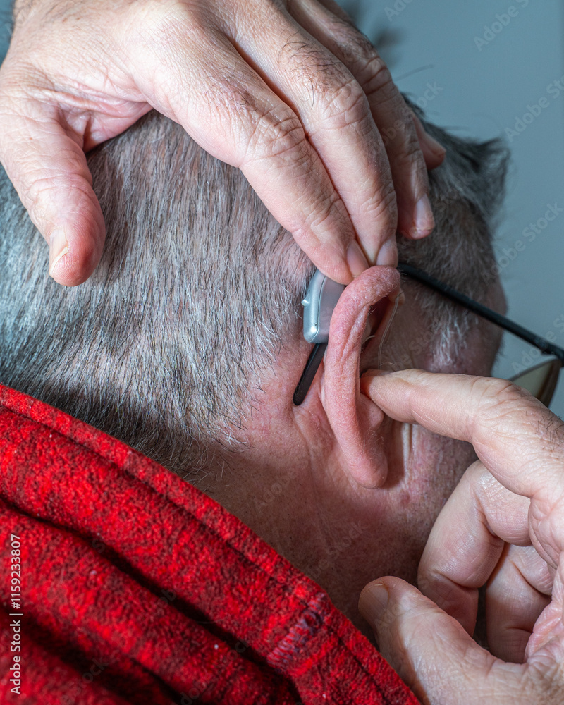 Grandfather putting on hearing aids to listen to his grandfather's music