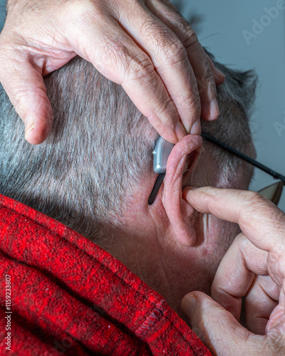 Obraz na płótnie Grandfather putting on hearing aids to listen to his grandfather's music w salonie