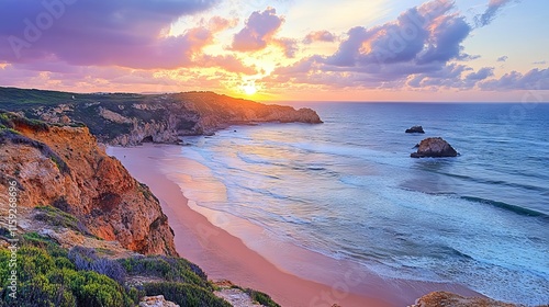 Vibrant sunset over praia da borderia beach with golden skies and rugged cliffs in carrapateira, costa vicentina, west coast algarve, portugal