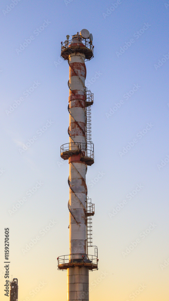 Naklejka premium Torre de chaminé em uma indústria, com emissão de fumaça, simbolizando o processo industrial e a infraestrutura de uma fábrica no setor de produção