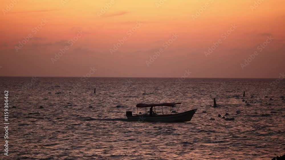 A boat sailing at sunset in the Caribbean A boat sailing at sunset in the Caribbean