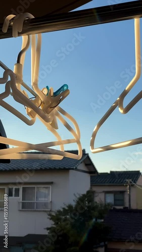 ベランダの物干し竿にかけたハンガーが風に揺れる 縦動画