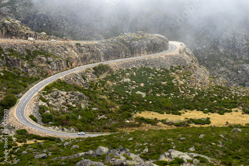 A winding road through the misty Serra da Estrela mountains on a foggy morning, creating a serene and mysterious atmosphere in Portugal's highest mountain range.