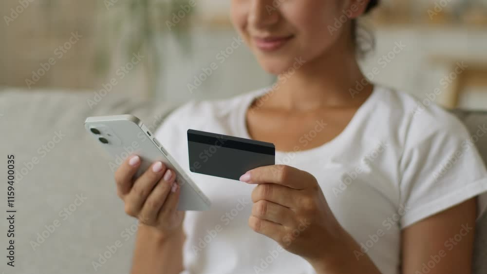 Happy smiling carefree Indian woman Arabian female girl buyer client enter secure number of credit bank card banking online mobile phone shopping smartphone distant purchase buy pay internet at home Happy smiling carefree Indian woman Arabian female girl buyer client enter secure number of credit bank card banking online mobile phone shopping smartphone distant purchase buy pay internet at home