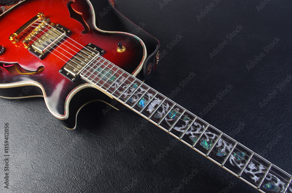 Fototapeta premium Red electric guitar on a black table.