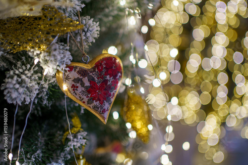 Heart-shaped ornament hangs on Christmas tree amidst golden lights and festive decorations