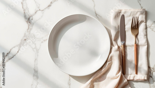 Elegant tableware mockup with white plate and gold utensils on a marble surface