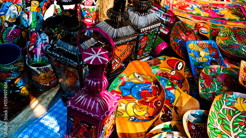 vibrant hand-painted cups, mugs, clay pots, wooden stools, tables with intricate patterns and chairs crafted by artisans from the villages of India photo