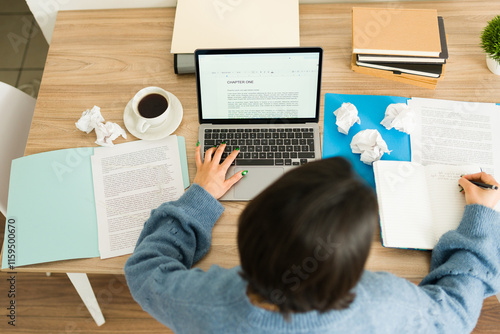 Photography Top view of  a young woman writing a book at home, using laptop and notebook, wi