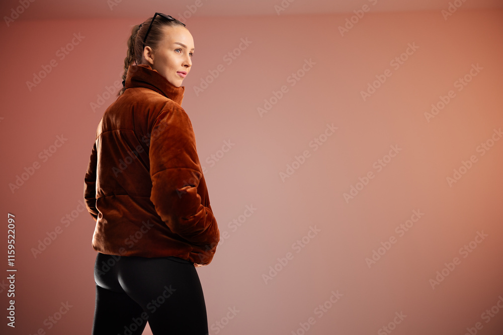 Obraz premium Young woman wearing brown coat posing in modern and clean studio setting
