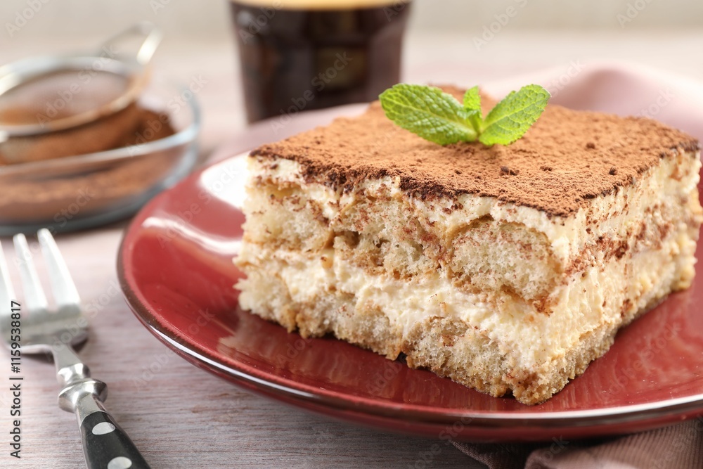 Delicious tiramisu with mint on light wooden table, closeup Delicious tiramisu with mint on light wooden table, closeup