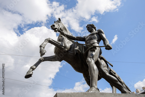sculpture of a horse tamer on the Anichkov Bridge in St. Petersburg, summer sunny day, lower angle