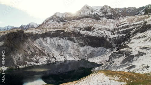 Epic landscape of the Ibón de Sabocos: drone reveals the magic of the frozen lake in Panticosa, Tena Valley, Aragon, framed by the snow-capped mountains of the Sierra de Tendeñera in the Pyrenees. photo