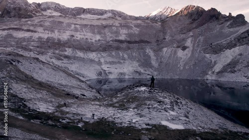 Drone reveals the winter magic of the Ibón de Sabocos in Aragon: a young man enjoys the snowy landscape in the Tena Valley, Pyrenees, while the flight captures breathtaking mountains and landscapes photo