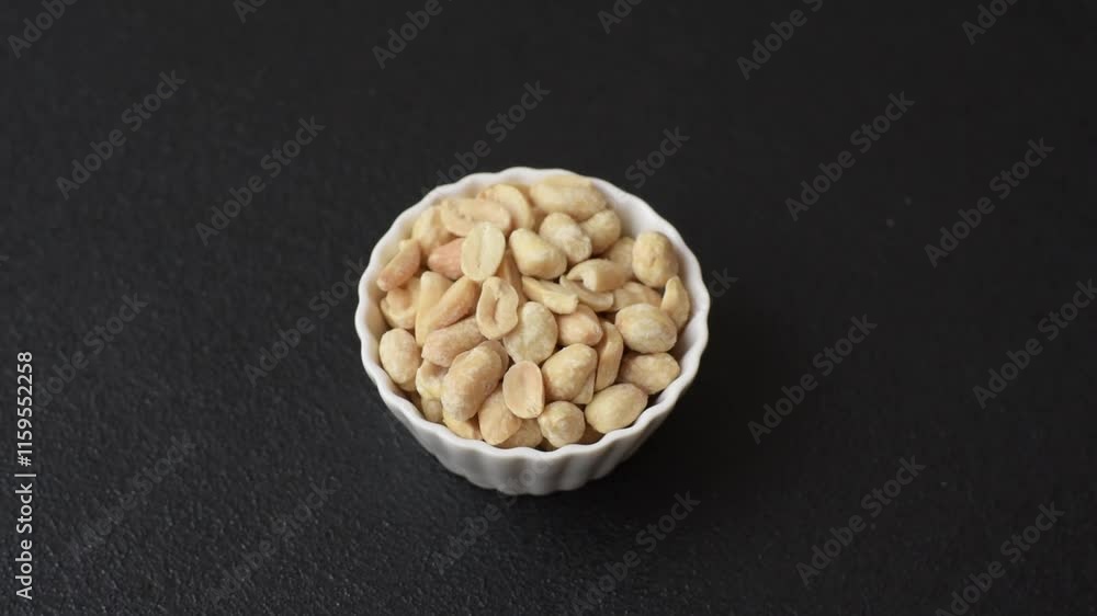 Delicious nutritious peanut in ceramic bowl on dark concrete background Delicious nutritious peanut in ceramic bowl on dark concrete background