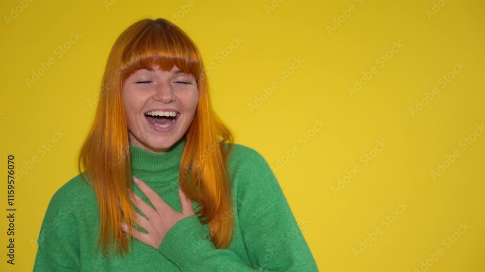 Bright yellow background highlights joyful woman with vibrant orange hair in green sweater Bright yellow background highlights joyful woman with vibrant orange hair in green sweater