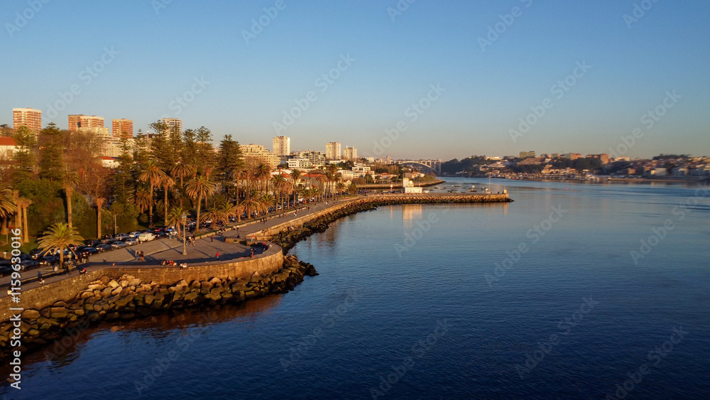 Vista capturando a deslumbrante paisagem do Porto e de Matosinhos, onde o Rio Douro encontra o Oceano Atlântico. A cena apresenta as areias douradas da praia de Matosinhos, 