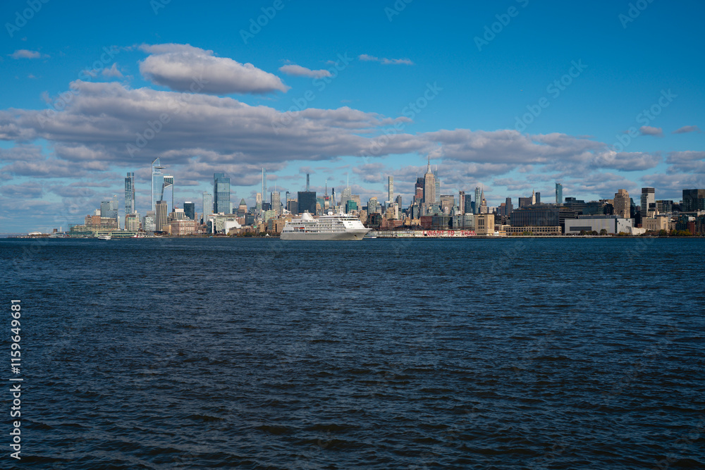 The city skyline of New York City in USA, United States. Blue sky day with iconic buildings. New York City NYC Manhattan Downtown Skyline, viewed from Jersey City, USA. The city skyline of New York City in USA, United States. Blue sky day with iconic buildings. New York City NYC Manhattan Downtown Skyline, viewed from Jersey City, USA.