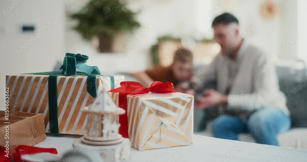 Close Up on Christmas Presents on Table with Dad and Little Boy in Background Playing Close Up on Christmas Presents on Table with Dad and Little Boy in Background Playing