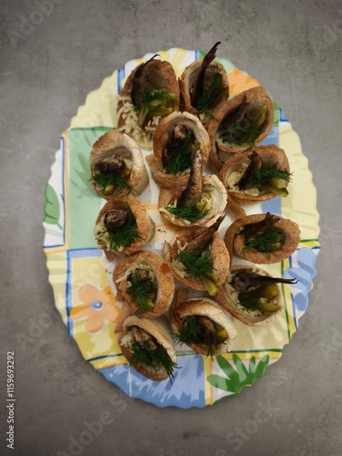 Christmas bread cups filled with sprats, pickles, and dill on festive plate in prague party food for aperitif, New Year's Eve dinner, Christmas or birthday photo