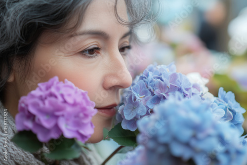 Mature businesswoman enjoys the fragrance of colorful flowers outdoors