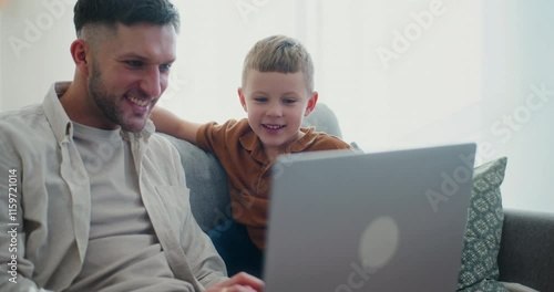 Dad and Young Son Sitting on Couch Enjoying Working on Laptop photo