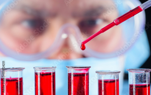 Blood test. Doctor working with patient's blood sample in lab. Serological testing in hospital. Medical scientist or laboratory assistant in mask and goggles analyzing blood sample in test tubes. photo