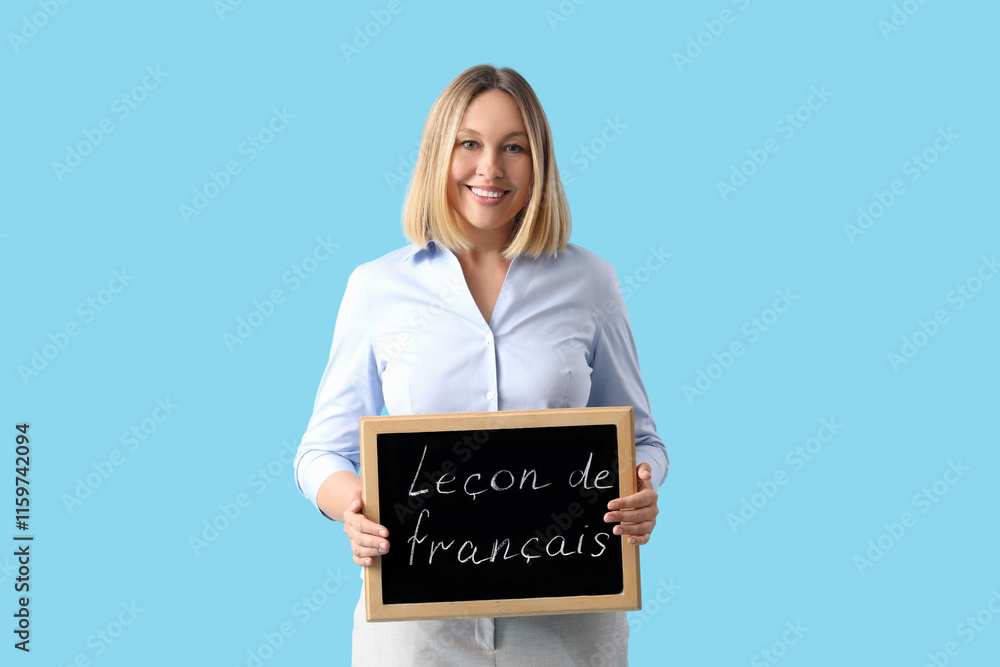 Female French language teacher with small blackboard on blue background Female French language teacher with small blackboard on blue background