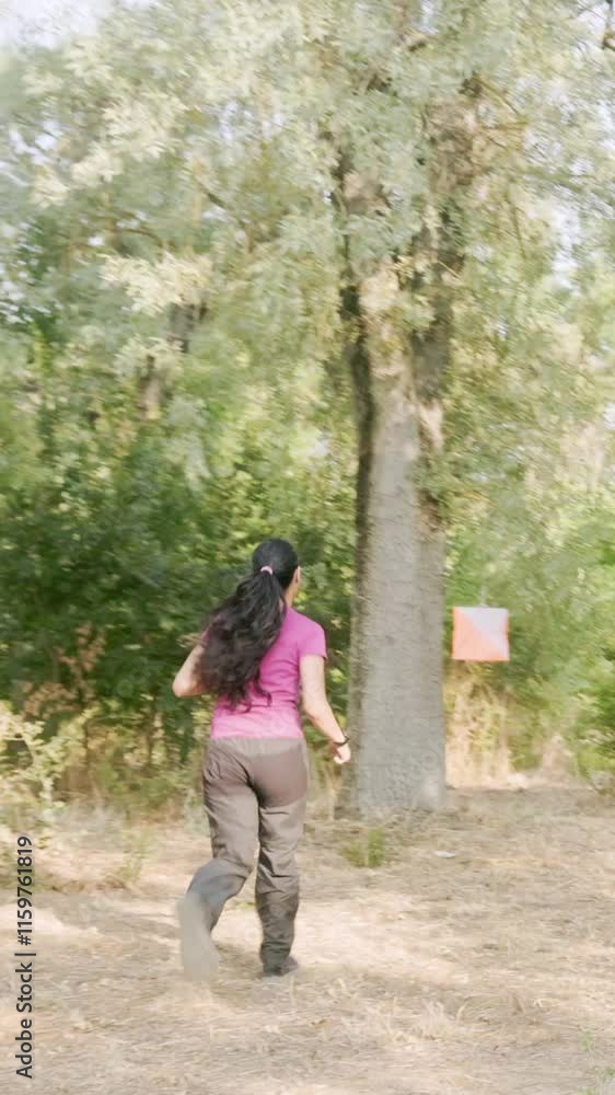 Venezuelan athlete navigating with map and compass in orienteering race. Young latinx venezuelan Venezuelan athlete navigating with map and compass in orienteering race. Young latinx venezuelan