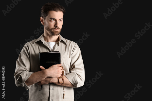 Serious young man holding h...