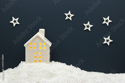 Christmas and New Year greeting card with glowing house in winter night snowy landscape