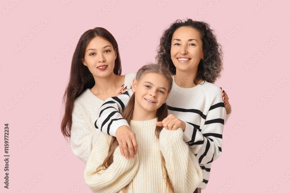 Mature woman with her daughters hugging on pink background Mature woman with her daughters hugging on pink background