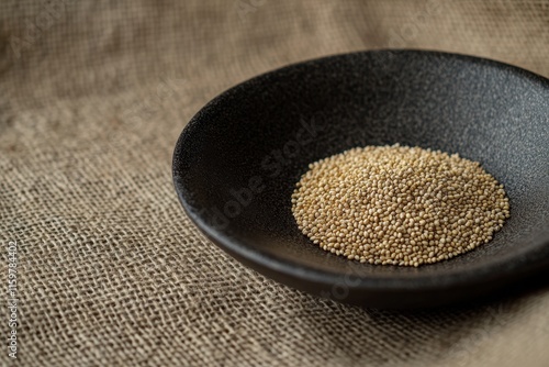 Adlay millet on a black plate against a burlap backdrop photo