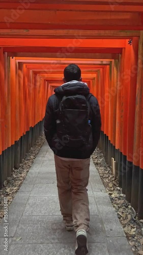 Tourist walking through fushimi inari shrine in kyoto, japan