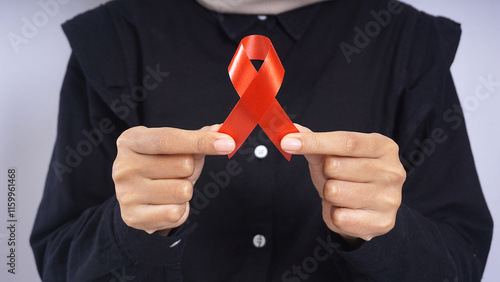 Hands holding tip of red ribbon  photo