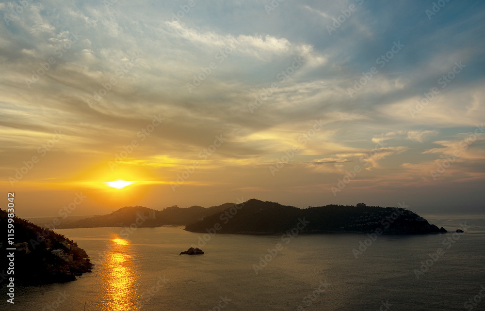 Beautiful sunrise at the entrance of the bay of Puerto Marques in Acapulco. The sun rises over the horizon announcing the arrival of a new day in this Mexican tourist destination. Beautiful sunrise at the entrance of the bay of Puerto Marques in Acapulco. The sun rises over the horizon announcing the arrival of a new day in this Mexican tourist destination.