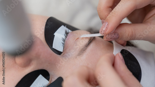 Canvas Print A specialist glues a client's drooping eyelid before eyelash extensions